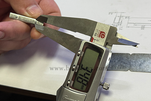 Digital caliper measuring a critical dimension of a custom metal part-3 Digital caliper measuring a critical dimension of a custom metal part-3