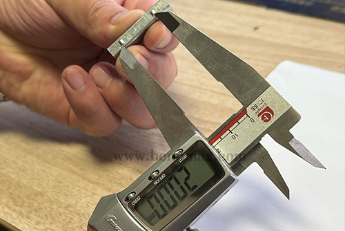 Digital caliper measuring a critical dimension of a custom metal part-2 Digital caliper measuring a critical dimension of a custom metal part-2